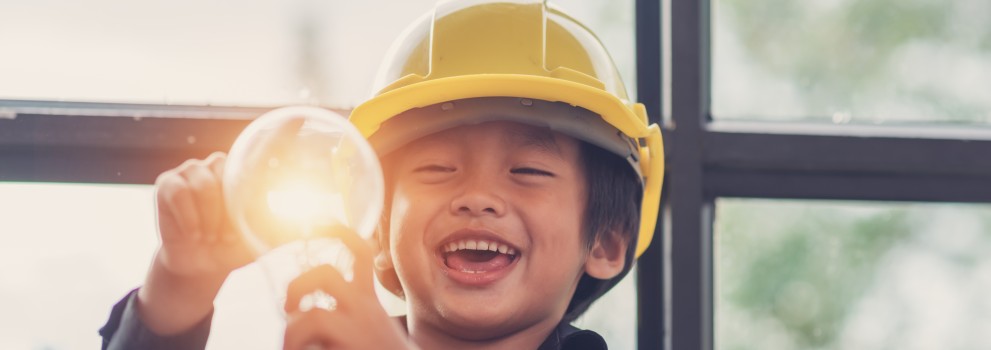 Smiling child holding a lightbulb